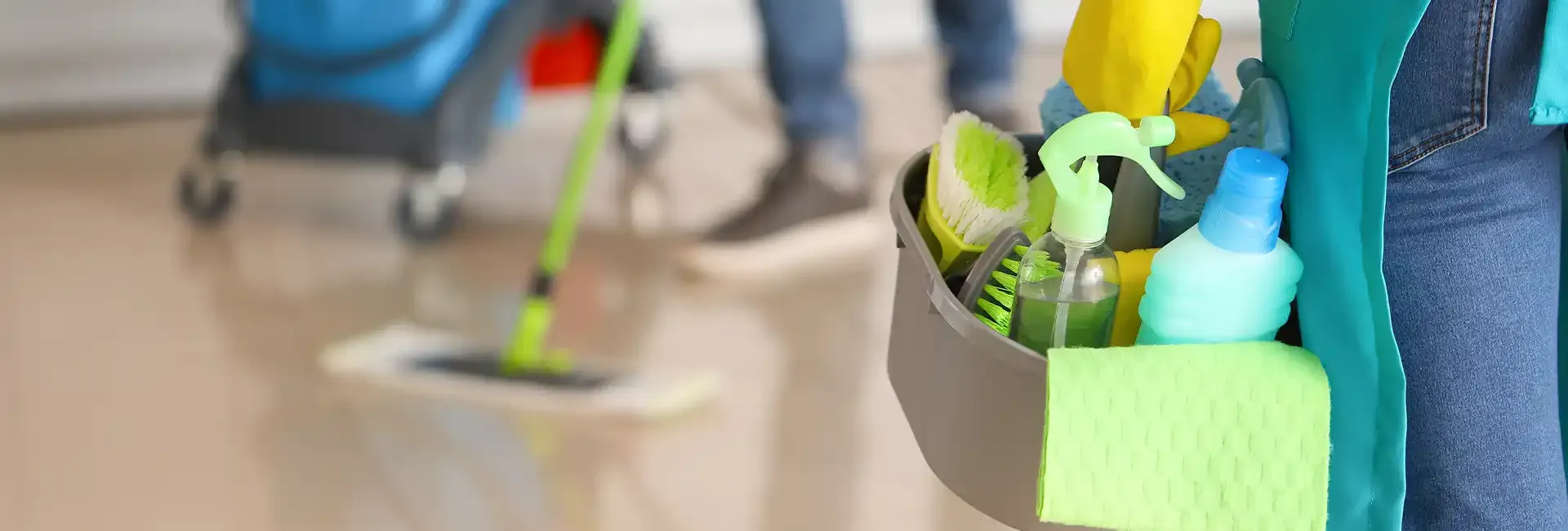 Mop and a caddy of cleaning supplies on a shiny floor