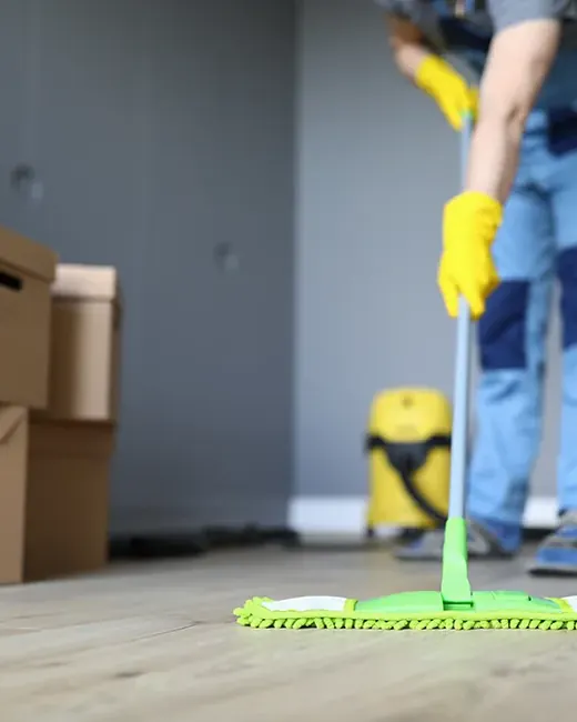 Floor being mopped in an empty room with moving boxes